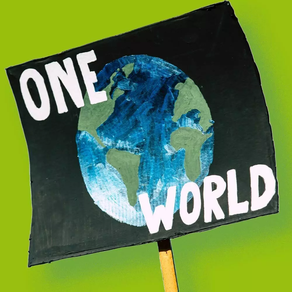 sign with inscription "One Wolrd" with the planet Earth