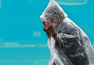 femme assise se protégeant de la pluie